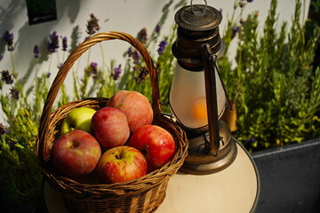 A gas lamp and apples in a basket in the garden.
