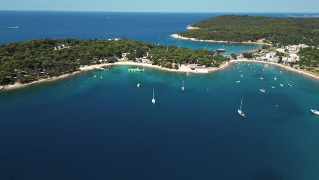 Aerial view of a narrow inlet with turquoise water and sailing boats along the coastline, Pula, Istria, Croatia.