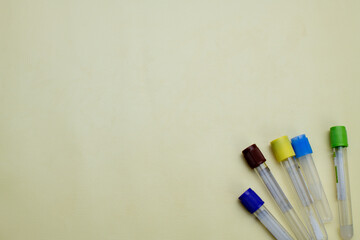 Vacuum tubes for collection and blood samples on yellow background with space for text