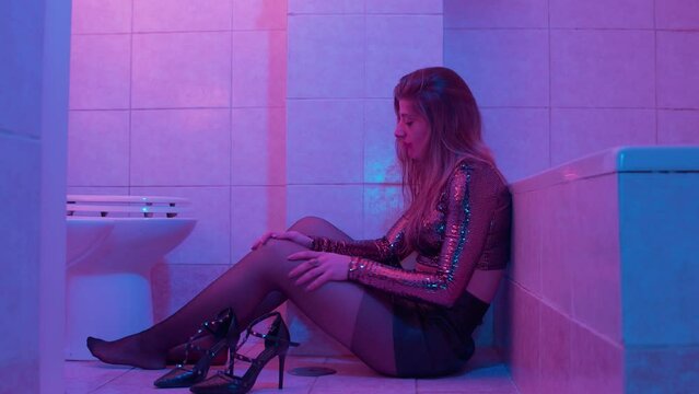 mental disorders - depressed girl in the bathroom tears off her pantyhose
