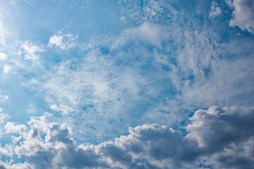 The sky above is a tapestry of serenity, with beautiful fluffy clouds set against a soothing blue background, where the sun occasionally peeks through.