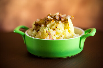 Cooked mashed potatoes with fried chopped bacon and onions.