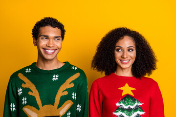 Photo of positive tricky lady guy wear new year ugly print sweaters looking each other isolated yellow color background