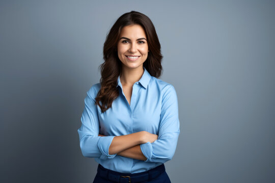 Smiling confident professional businesswoman standing with arms crossed against gray background. corporate portrait.