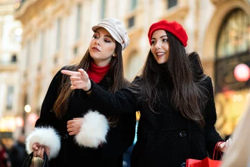 Photo sur Plexiglas Milan Two attractive smiling young women are shopping in the city