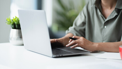 Businesswoman using laptop with technology to typing and working about calculation tax in office