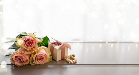 Rose fresh flowers bouquet on gray table by the window with gift box banner