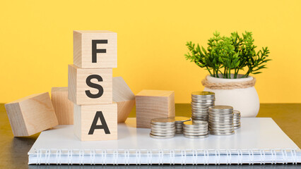 FSA - text on wood cubes stack, yellow background