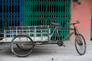 old bicycle in the street in front of house 