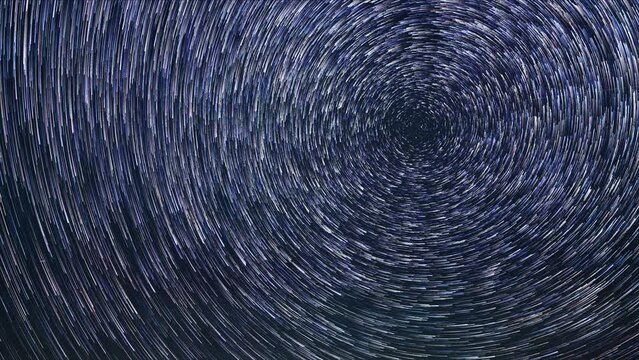 Looking straight up into the night sky at a million stars in this time lapse. The stars are enhanced using a star trail or comet mode technique that creates a circular pattern.  

