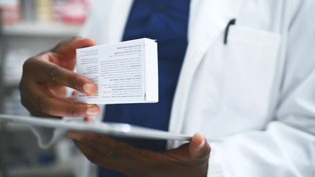 Black man, hands and pharmacist with tablet, box or medication for inventory inspection at store. Closeup of male person or doctor with technology checking pharmaceutical stock or drugs at pharmacy