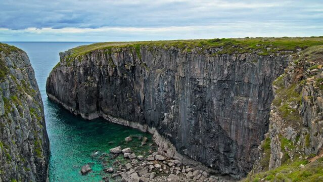 Turquoise water by the two big cliffs in Pembrokeshire Coast National Park. Green Irish Sea and rocky formation in Wales.