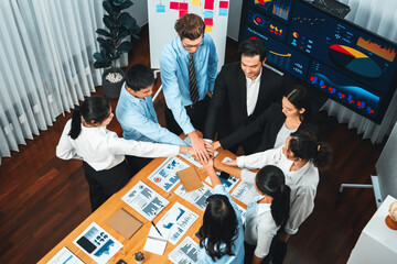 Multiracial business people make synergy hand stack together in meeting room as cooperation or team building for corporate employee in workplace. Habiliment