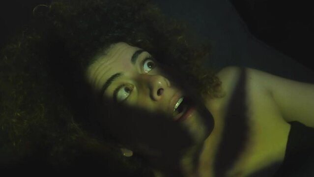 distraught face of frightened problematic young woman staring at a flashing light