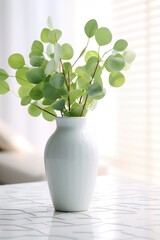 A simple white vase filled with fresh green leaves. This image can be used to add a touch of nature and freshness to any design or decor