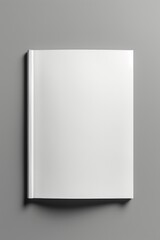 A white book placed on a gray surface. This versatile image can be used in various contexts