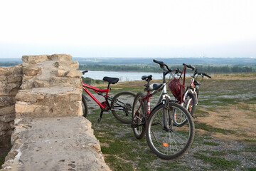 Fototapeta premium Panoramic evening view of the reservoir from the high river bank with ancient ruins. At the historic ruins are a few bicycles.