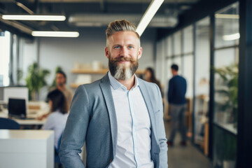 Confident and smiling handsome hipster man standing in the office	