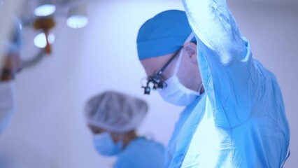 A professional surgeon performs heart surgery in a medical facility together with a well-coordinated team of doctors