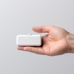 A hand holding a compact pill box.