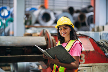 Portrait of happy industrial worker looking camera at factory machines. Technician working in metal sheet at industry.