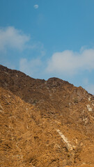 Fujairah mountains, extension of Omani Al Hajar mountain range. Cloudy winter day on empty street.