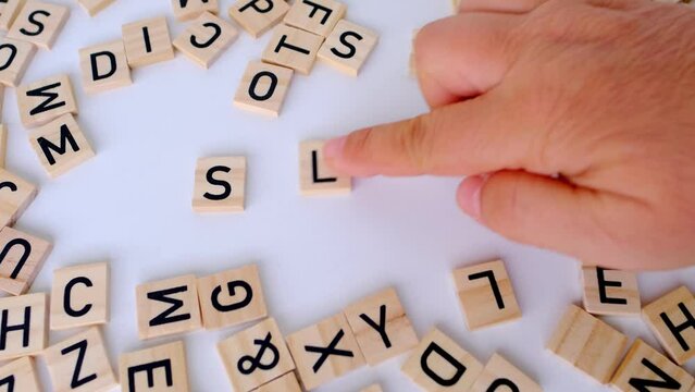 female hand close-up collecting words sleep - deep on table made of wooden letters, concept transitioning into deep sleep, making it suitable for articles on sleep science and medical discussions