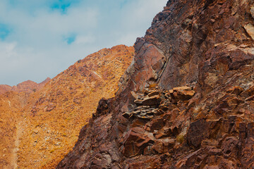 Fujairah mountains, extension of Omani Al Hajar mountain range. Cloudy winter day on empty street.