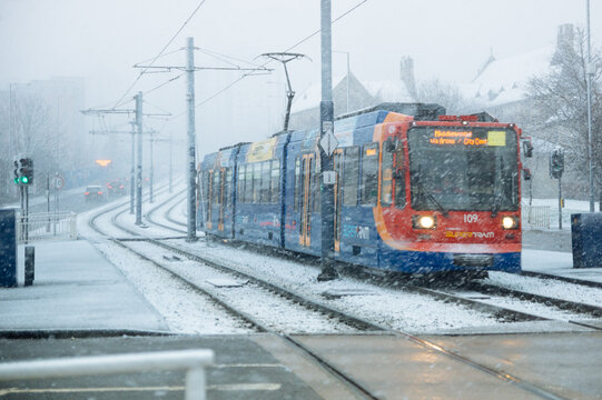 Sheffield supertram moving through the city on a snowy day in Winter