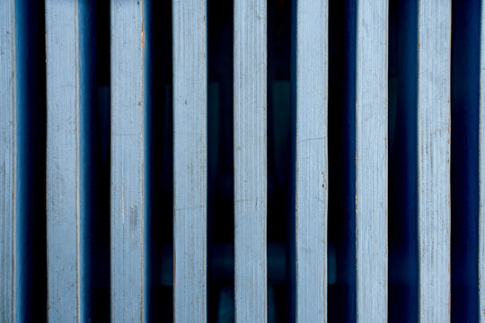 Blue pattern of a wooden bench with curved geometry, vertical slats