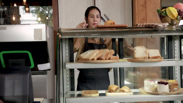 Asian barista female employee wearing apron uniform open cafe bakery shop small business owner services customer woman in front of counter takeaway, business entrepreneur start-up using POS machine