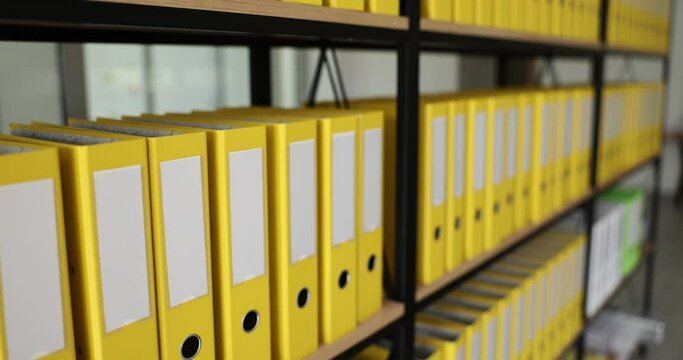 Yellow folders with materials and documents on shelves