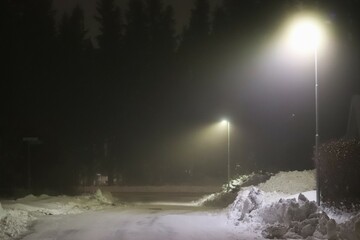 Night in fog one winter. Outdoor lighting in snowy weather.