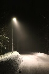Night in fog one winter. Outdoor lighting in snowy weather.