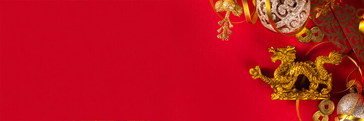 Chinese New Year 2024 greeting card. Bright red asian year of the dragon background with golden dragon figurine, Chinese lanterns, traditional jewelry, gifts, coins, cookies with wishes, copy space