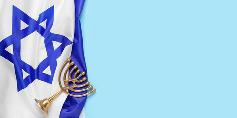 Menorah and flag of Israel on light blue background with space for text. Hanukkah celebration