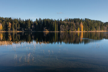 Picturesque landscape of bank of the lake Bolduk in sunny autumn day. Hiking near the lake along the Blue Lakes tourist route. 