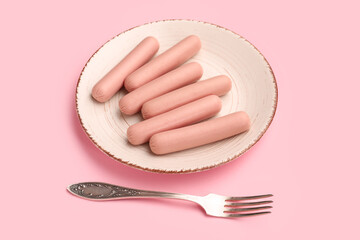 Plate with tasty thin sausages on pink background