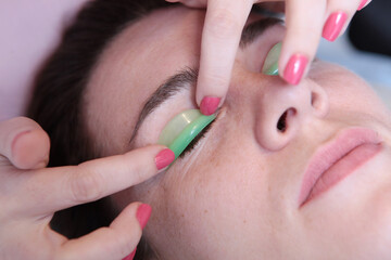 Eyelash extension for a girl in a beauty salon. The concept of beauty.Eyelash care procedures....