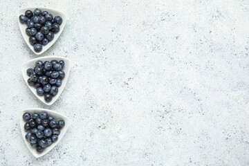 Bowls with fresh blueberries on white background