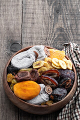 Dried fruits in wooden bowl on rustic background