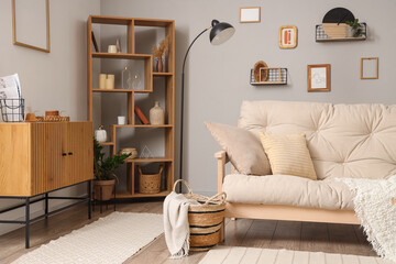 Interior of light living room with couch and shelf unit