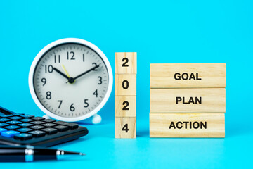 2024 New Year Goal Plan Action on wood block blue background