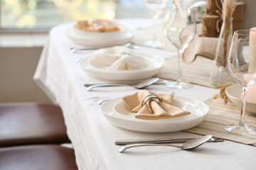 Elegant table setting with candles, folded napkins and plates