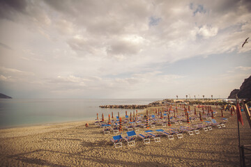 Deserted beach with sunbeds and umbrellas at the Italian Adriatic coast in the preseason, Italy....