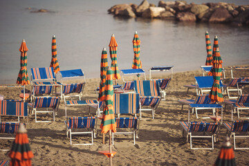 Deserted beach with sunbeds and umbrellas at the Italian Adriatic coast in the preseason, Italy....