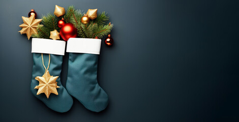 Flat lay with stockings filled with gifts and branches of Christmas tree placed on dark blue background with copy space. Three Kings Day, Epiphany day, Christmas.
