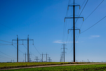 Electric poles, high-voltage towers, field.