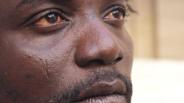 close up portrait of unhappy young african man opening his eyes looking ahead