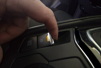 Driver pulling the electric parking brake of his car